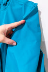 Manteau imperméable turquoise à capuchon seconde main - Outbound- La Penderie du Paradis